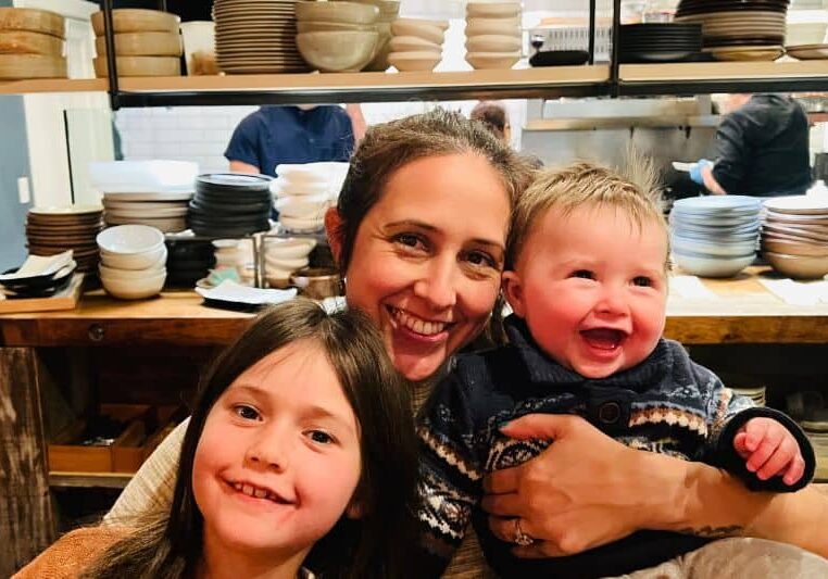 talia moore, infant feeding specialist, with her two young children in a kitchen.